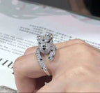 Silver panther ring on a hand with a newspaper background