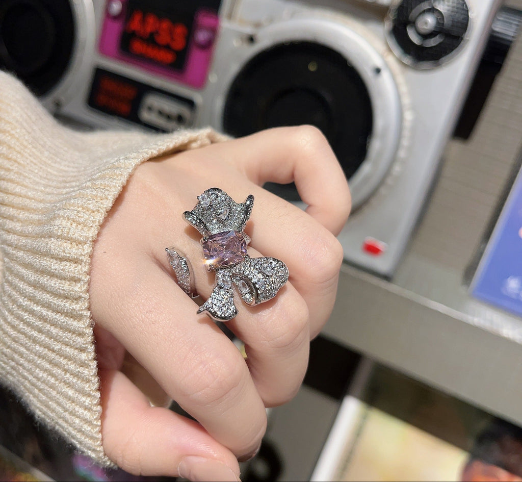 Hand wearing a decorative ring with a vintage radio in the background