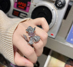 Hand wearing a decorative ring with a vintage radio in the background