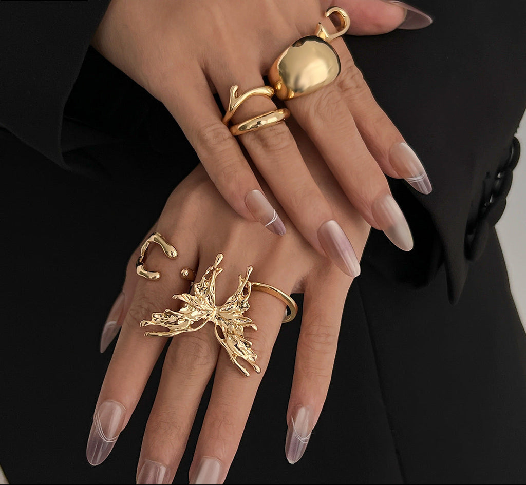 Close-up of hands wearing gold rings with a black background