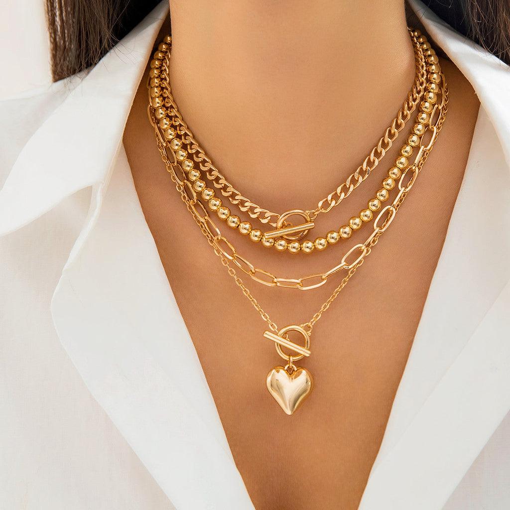 Gold necklaces with a heart pendant on a white background