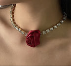 Necklace with a red rose pendant on a person's neck