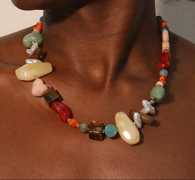 Colorful beaded necklace on a person's neck with a neutral background