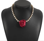 Necklace with a red rose pendant on a black mannequin bust, brand 'J N7' visible.