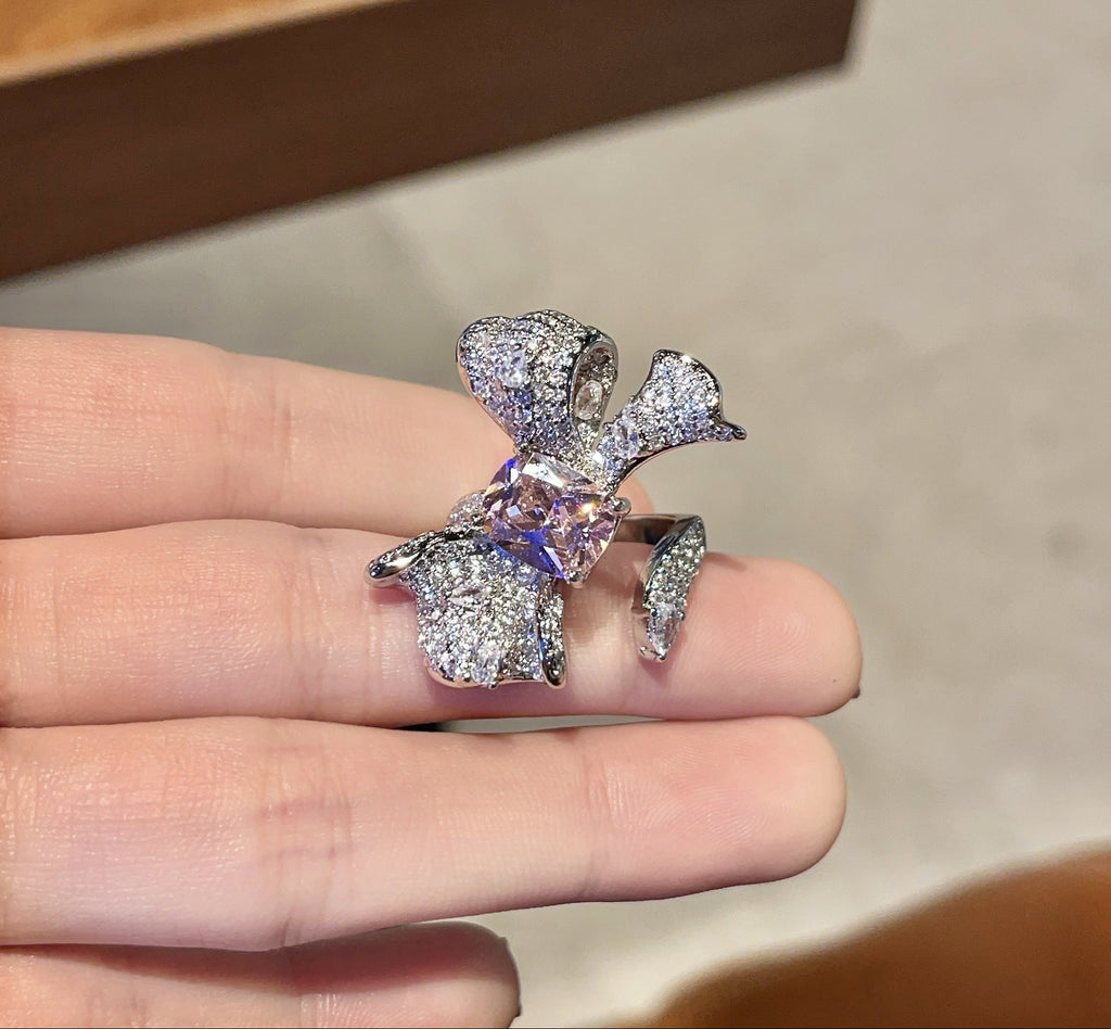 Silver ring with a large diamond on a hand against a neutral background