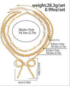 Gold necklace with bow pendant and measurements on a white background