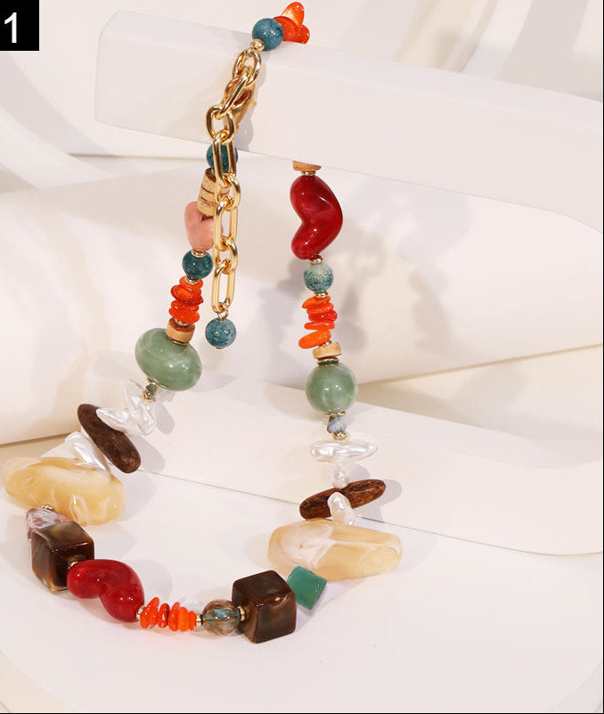 Colorful beaded necklace on a white surface with 'J N11' branding.