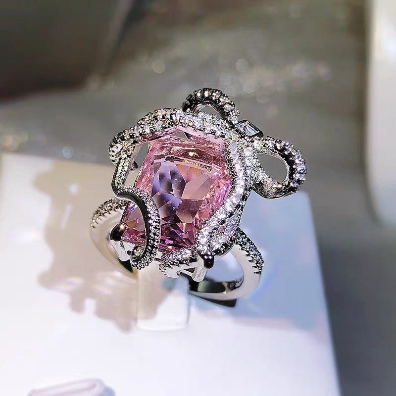 Ring with a large pink gemstone and silver accents on a neutral background