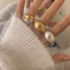 Close-up of a hand wearing multiple rings with a soft background