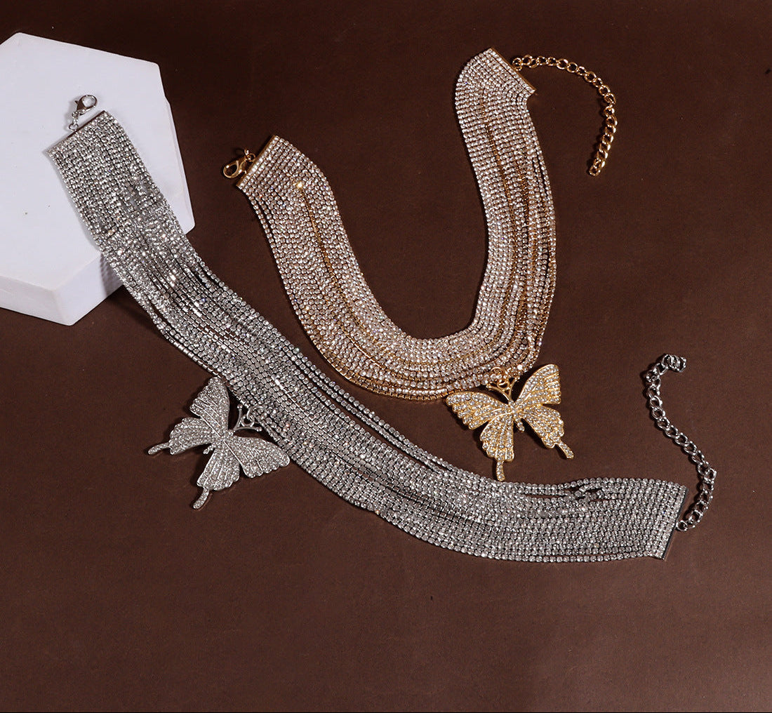 Gold and silver choker necklaces with butterfly pendants on a brown background